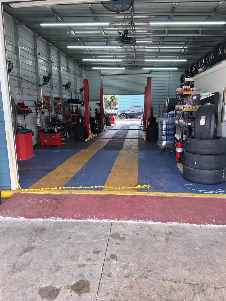 Clean service bays with two car lifts, a tire changer and tire racks inside the shop