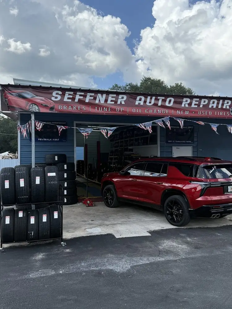 Seffner Auto Repair shop front with its sign, tire racks and a red SUV parked in the bay