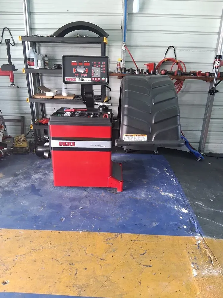 Red wheel balancer ready for tire balancing inside the shop's service bay